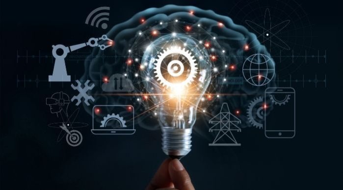 Graphic of fingers holding a light bulb with visual elements emanating from it such as a mobile phone, wifi symbol, globe, and a person wearing a VR headset.